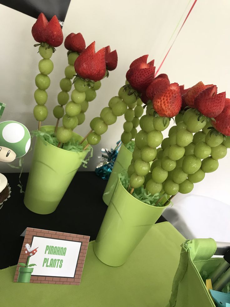 there are some strawberries and grapes in the vases on the table with other decorations