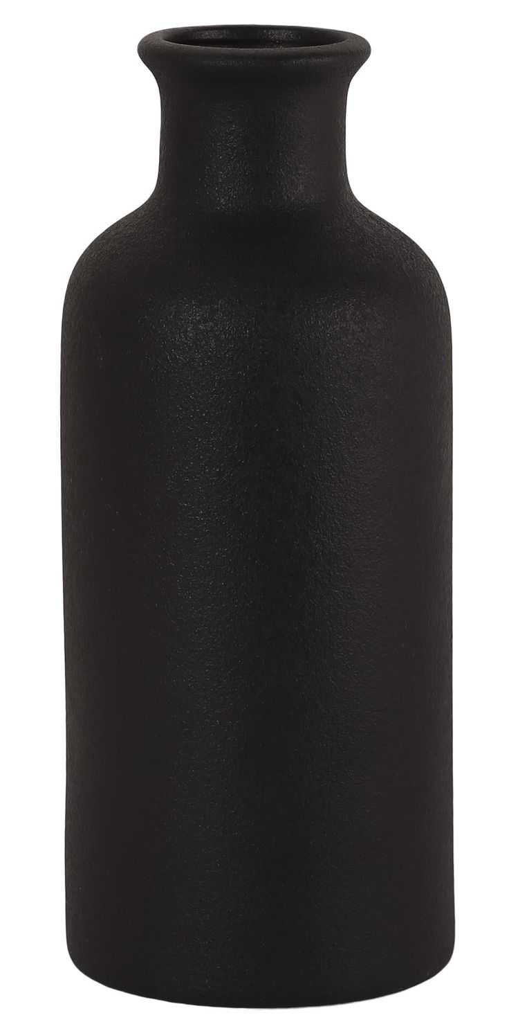 a black vase sitting on top of a white table