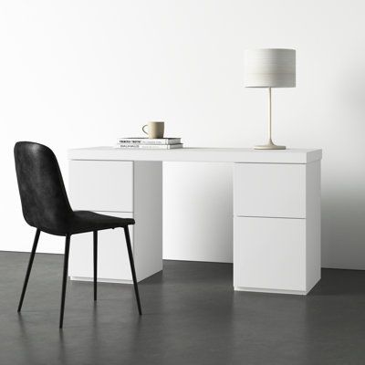 a white desk with a black chair next to it and a lamp on top of it