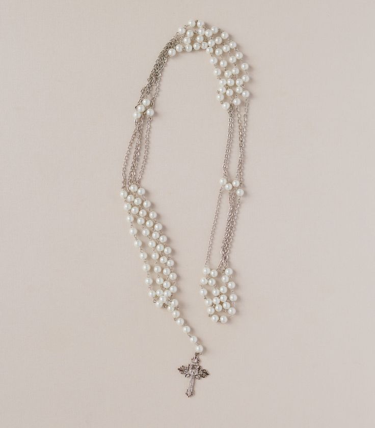 a necklace with pearls and a cross on it