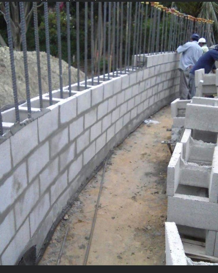 two men are working on the construction of a wall