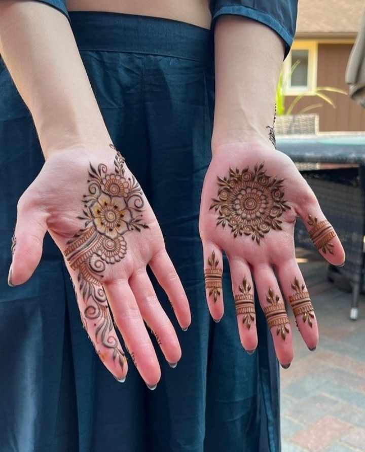 two hands with henna designs on them