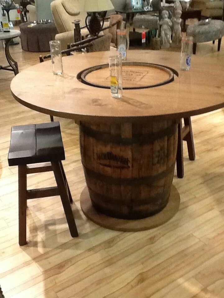 a wooden barrel table sitting on top of a hard wood floor