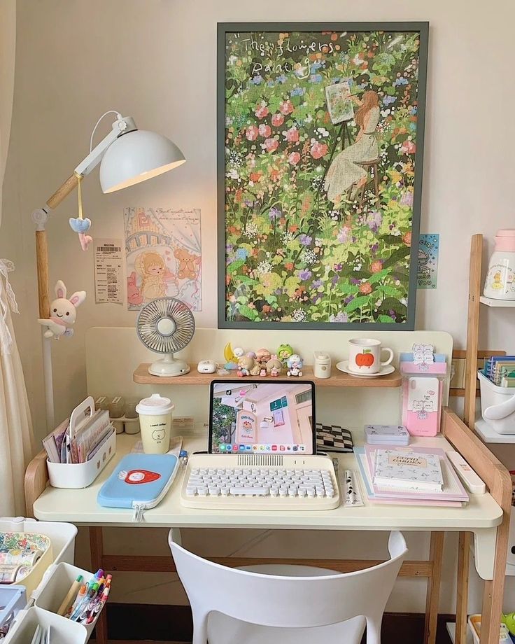 a white desk topped with a laptop computer next to a chair and table covered in books