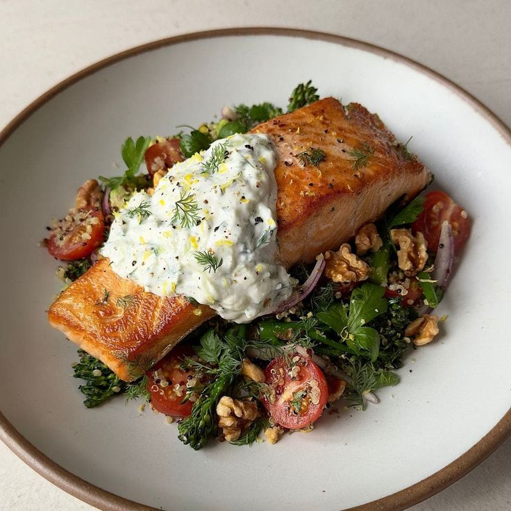 a white plate topped with salmon and vegetables