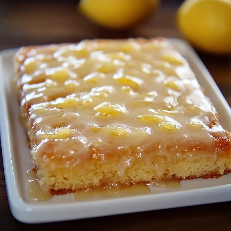 a piece of cake sitting on top of a white plate next to some lemons