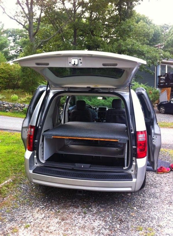 the back end of a silver van with its trunk open