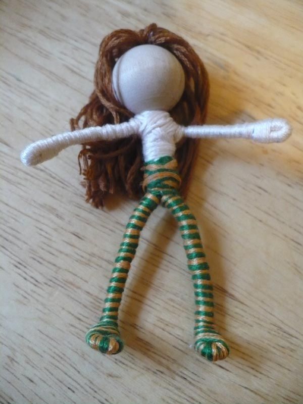 a doll with long red hair and green striped legs