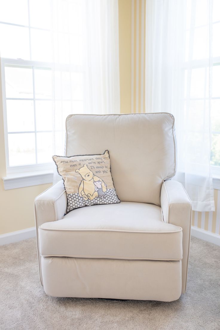 a white chair with a winnie the pooh pillow on it