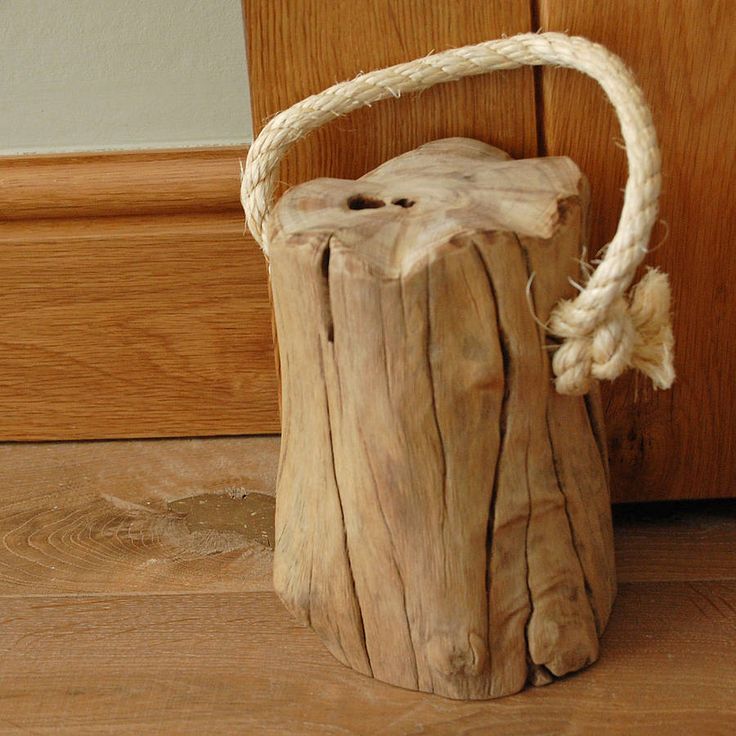 a piece of driftwood is tied up to a door handle and sitting on the floor