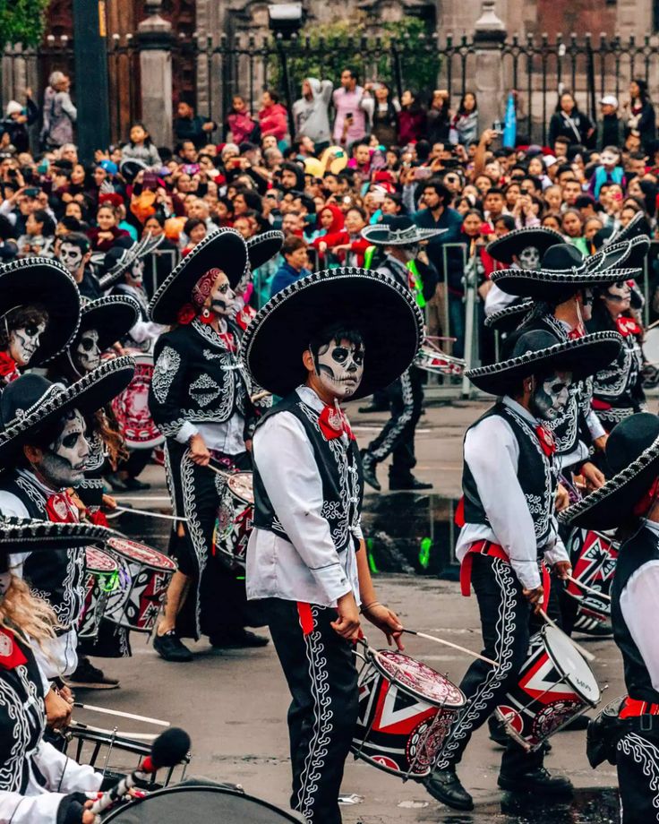 a group of people that are standing in the street with some hats on their heads