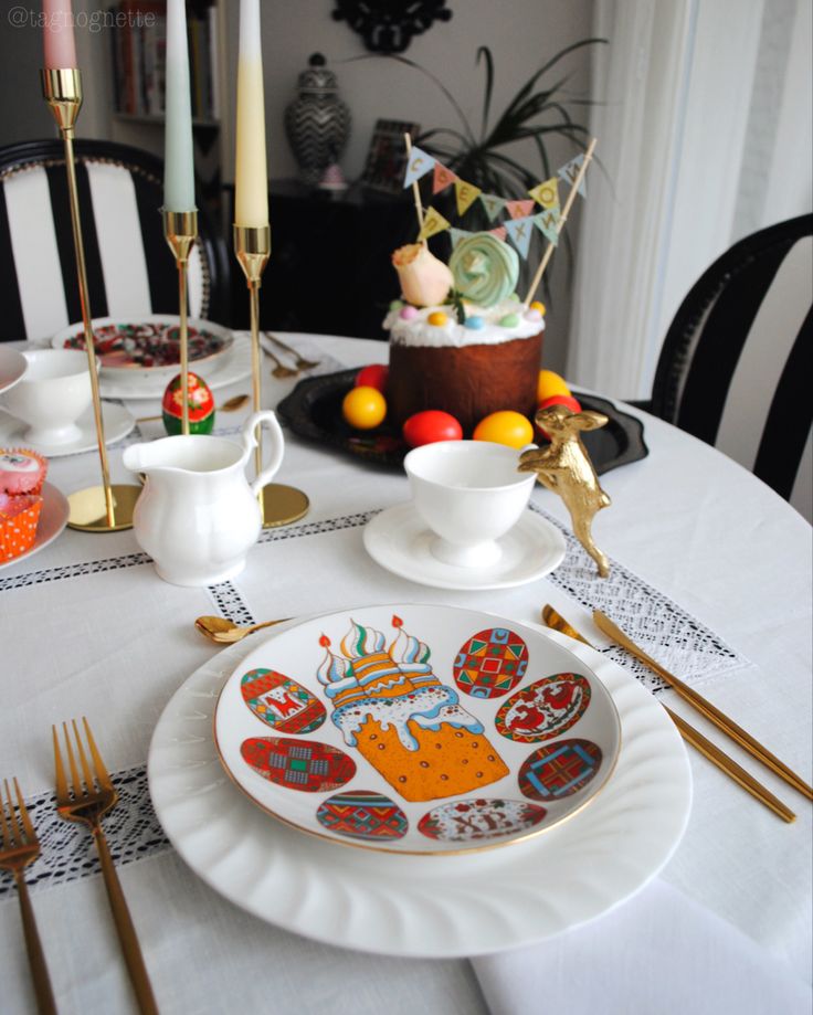 a white table topped with plates and silverware