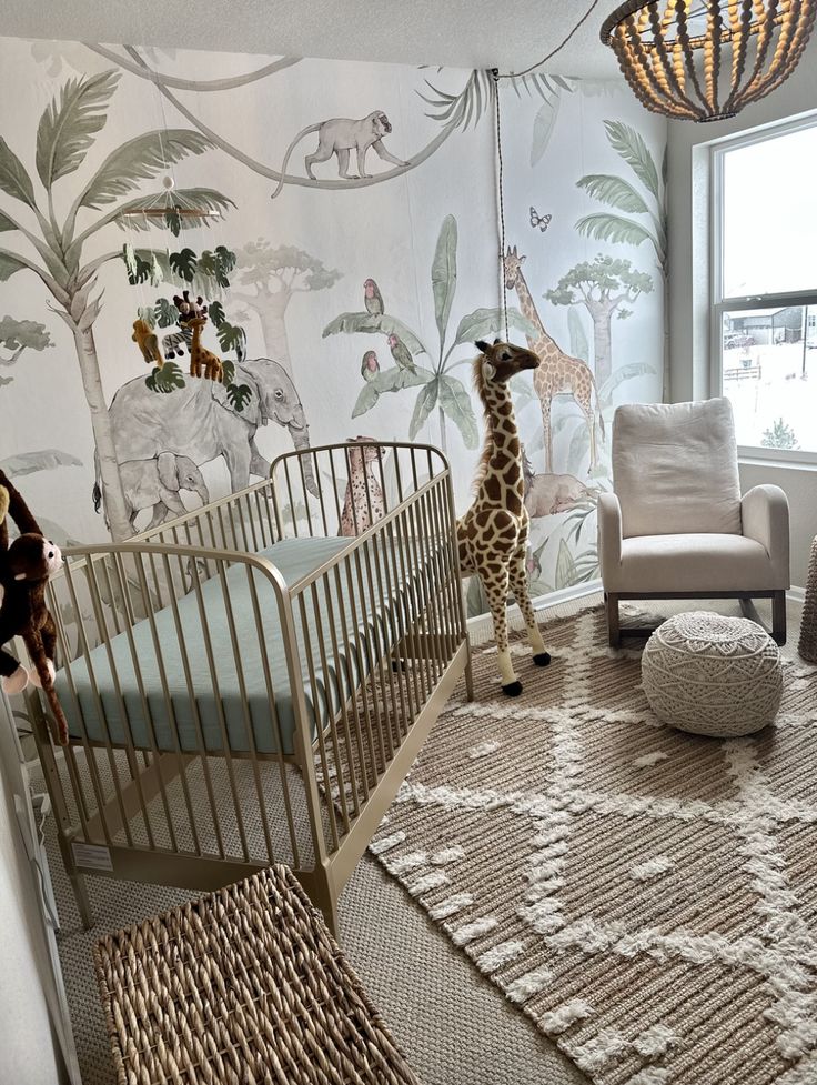 a baby's room with giraffes and other animals on the wall