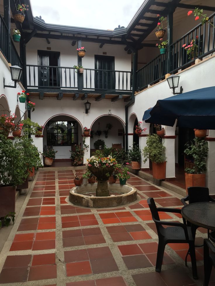 an outdoor courtyard with tables and umbrellas