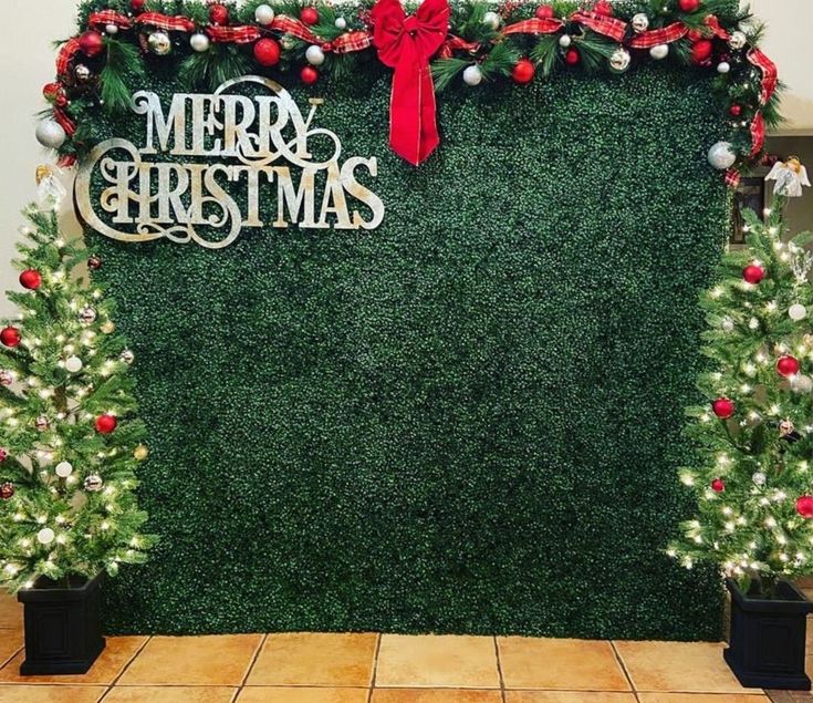 christmas decorations on display in front of a green wall