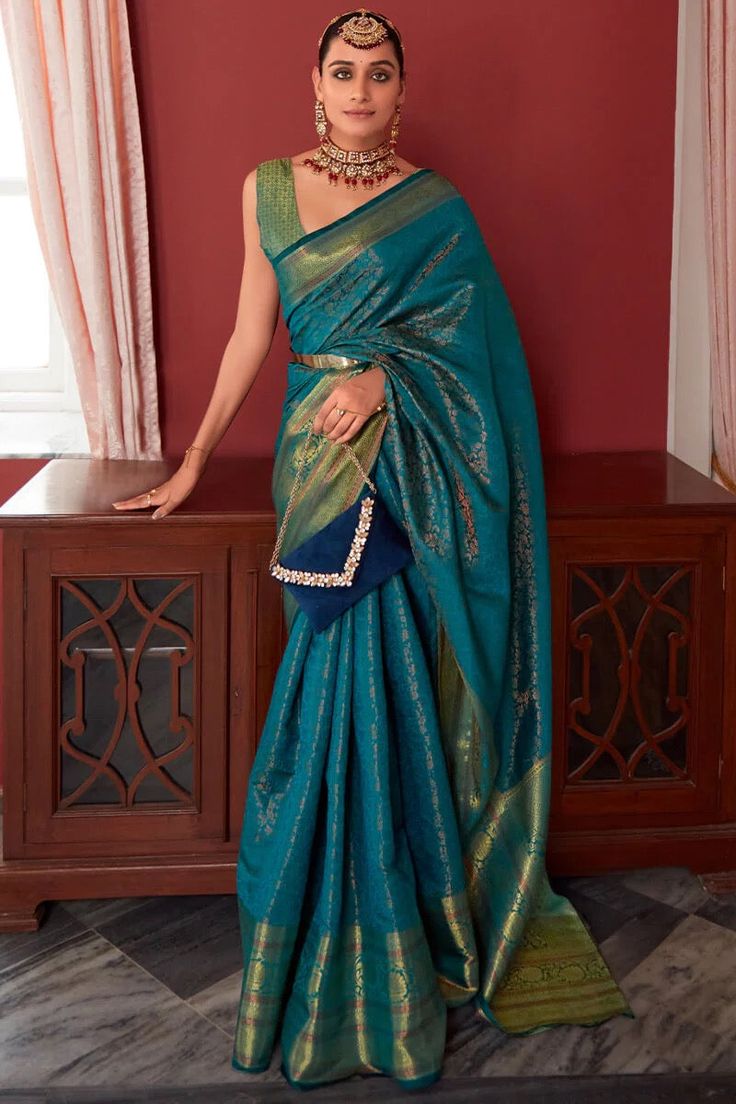 Experience the timeless charm of our Kanchipuram Silk Saree, paired with a stunning blouse piece. Meticulously crafted, this saree effortlessly enhances your elegance and grace. Made from luxurious silk fabric, it offers a rich and indulgent feel, while the intricate motifs and vibrant colours add a touch of traditional beauty. This saree comes with matching unstitched silk blouse piece and it can be customised by us on your request or you can stitch to fit your size. Select “ Help - custom stitching” option to find out more. You can also choose a matching fully stitched and drawstring adjustable waist skirt from our skirts collection to go with the saree. Saree length : approximately 5.8 metres Saree width : approximately 1.2 metresBlouse piece: approximately 0.8 metres Fabric : Kanchipur Pleated Saree, Blue Silk Saree, Silk Saree Kanchipuram, Salwar Dress, Dress Salwar Kameez, Kanjivaram Silk Saree, Indian Silk Sarees, Simple Sarees, Lehenga Collection