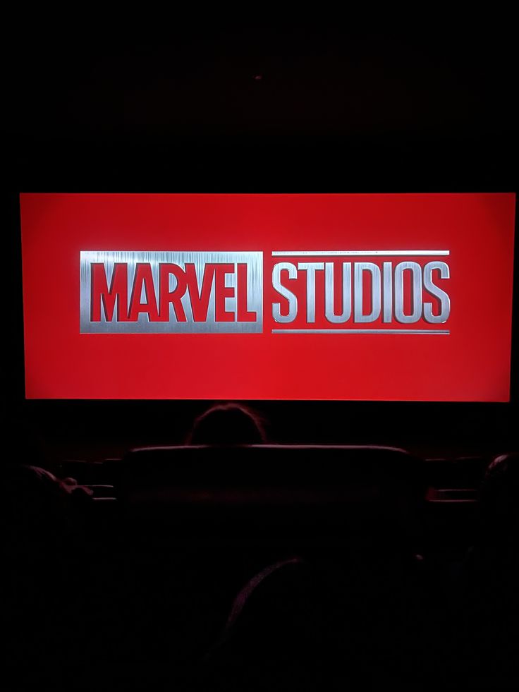 the logo for marvel studios is displayed on a large screen in a dark room with black lighting