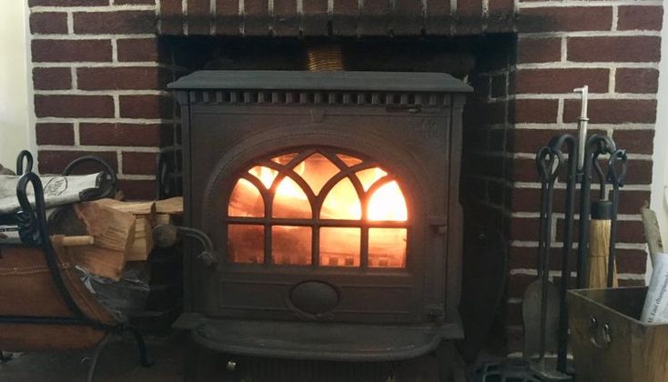 a wood burning stove in a brick fireplace