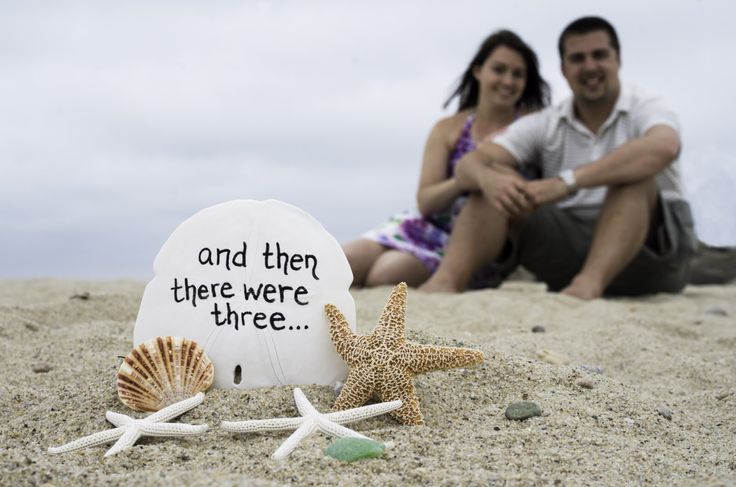 a couple sitting on the beach next to shells and starfish with a message written on it