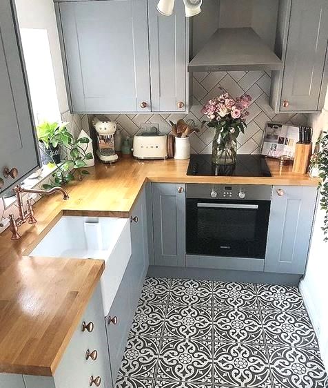 a kitchen with grey cabinets and wooden counter tops