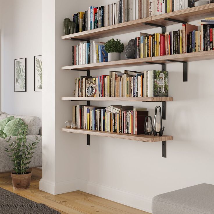 a living room filled with lots of books on shelves next to a couch and window