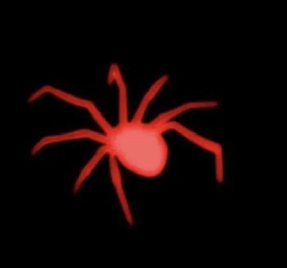 a red spider sitting on top of a black surface