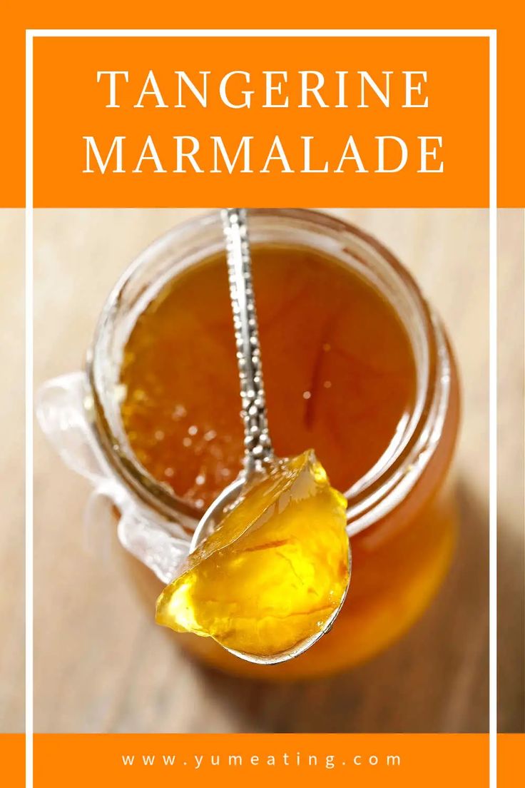 a jar filled with orange marmalade sitting on top of a wooden table