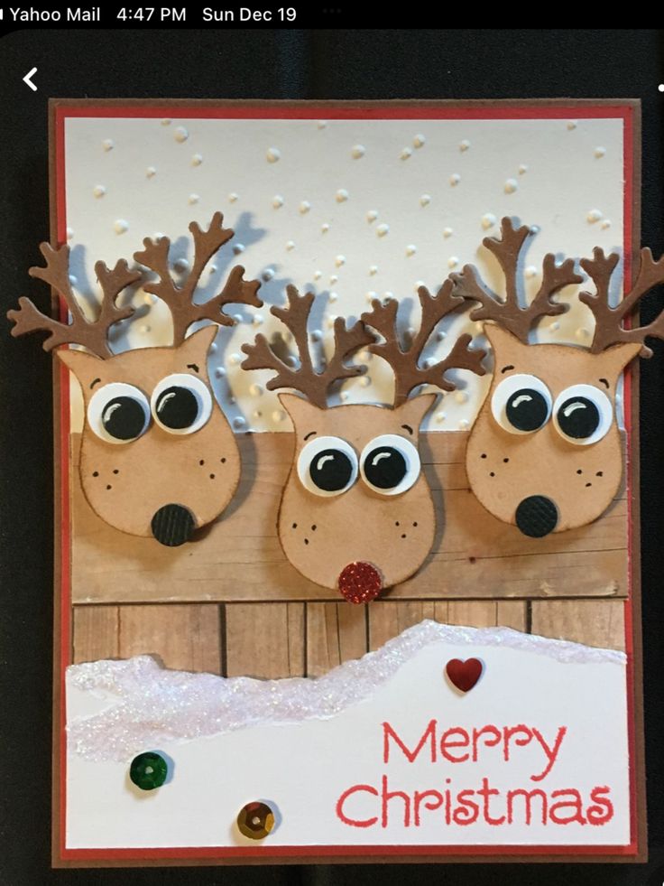 a christmas card with three reindeer heads on it