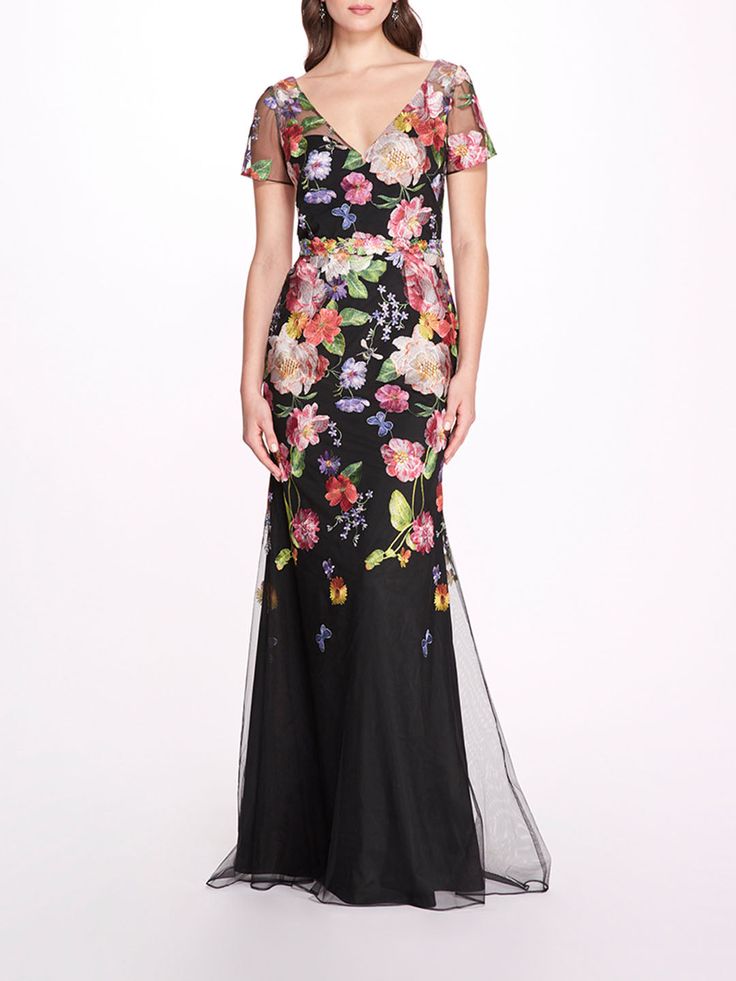 a woman in a black and pink floral print evening gown with sheer mesh overlays