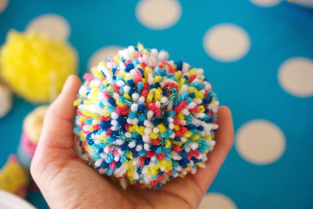 a hand holding a colorful sprinkle covered donut