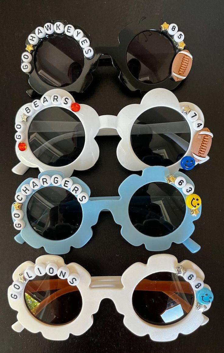 Cheer on your favorite team or player with these adorable custom kid's sunglasses! HOW TO ORDER: -Select sunglass color In the personalization box, include: -Team Name & Number (ex. Panthers & 60) OR Only Team Name (ex. Grandview Bobcats with rhinestones) -Team Colors -Sport bead (optional) Options are: Football, Basketball, Soccer, Baseball, or Volleyball -Rhinestone outline (ex. Ohio State option) Yes or No Custom sunglasses are final sale. Customizable White Adjustable Sunglasses, Trendy White Sunglasses With Custom Name, Beaded Sunglasses Ideas With Words, Custom Name Sunglasses As Summer Gift, Softball Sunglasses, Customizable Fun Plastic Sunglasses, Personalized Kids Sunglasses, Playful Personalized Beach Sunglasses, Football Basket