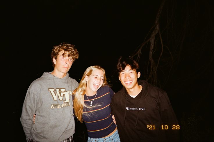 three young people standing next to each other