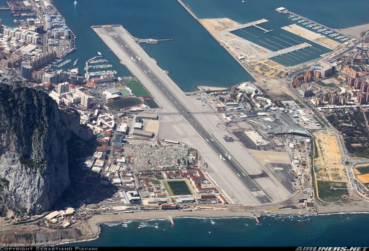 an aerial view of the airport and its surrounding area, with mountains in the background