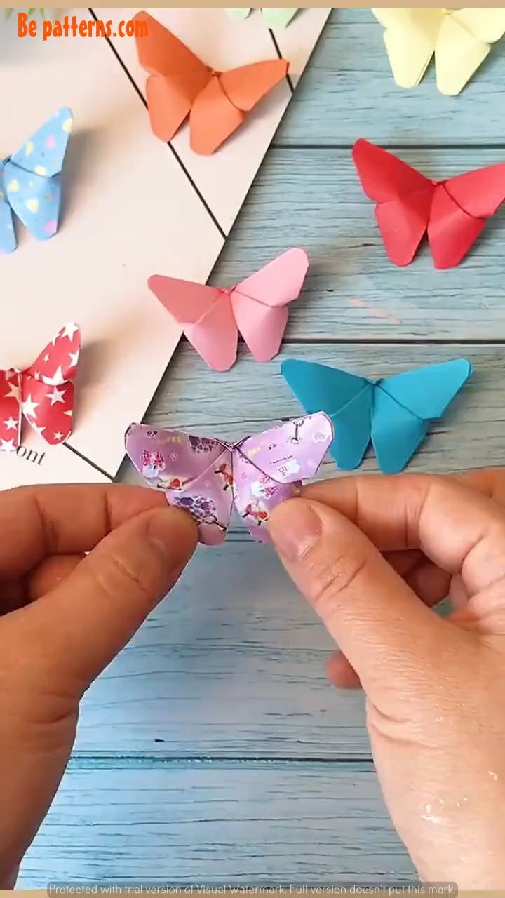 someone is making origami butterflies out of paper