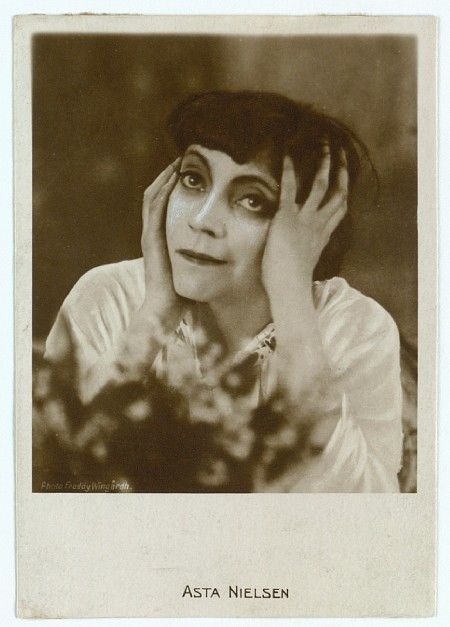 an old black and white photo of a woman holding her hands up to her face