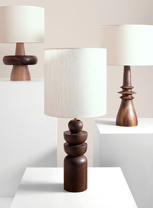 three wooden lamps sitting on top of a white table