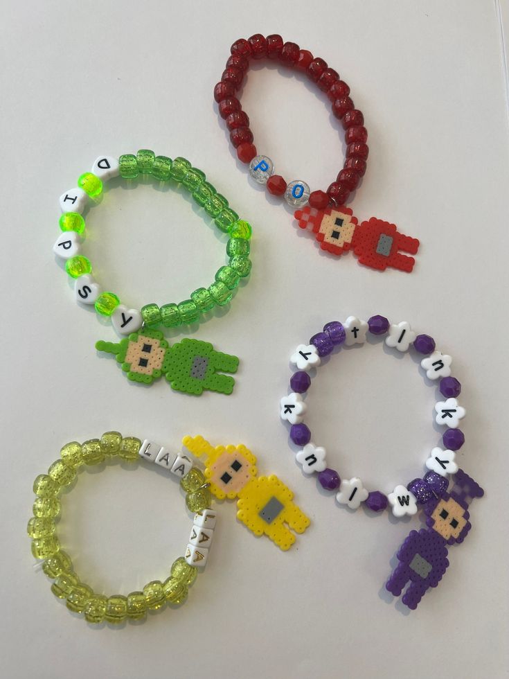 four different bracelets with beads and charms on top of a white surface, each featuring an image of the same character