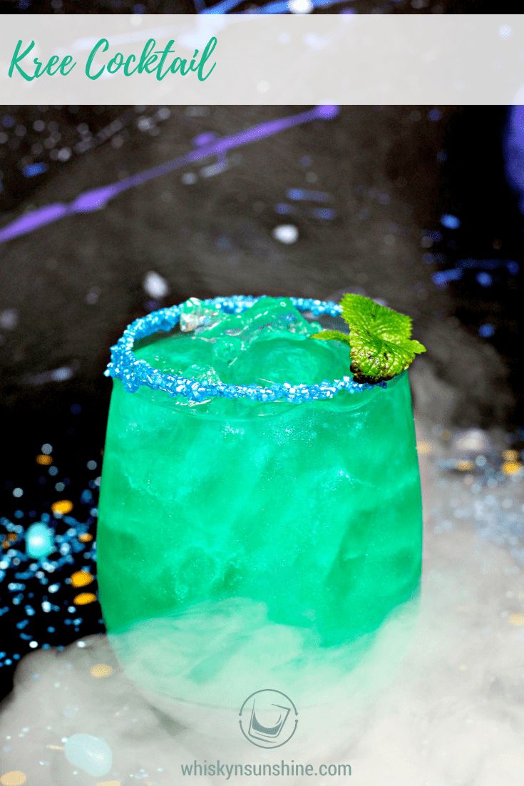 a green and blue drink with sprinkles on the rim, sitting in snow