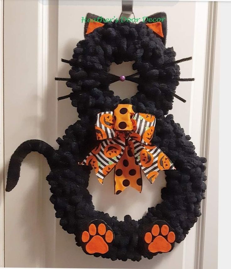 a black cat wreath with orange and black polka dots on it's front door