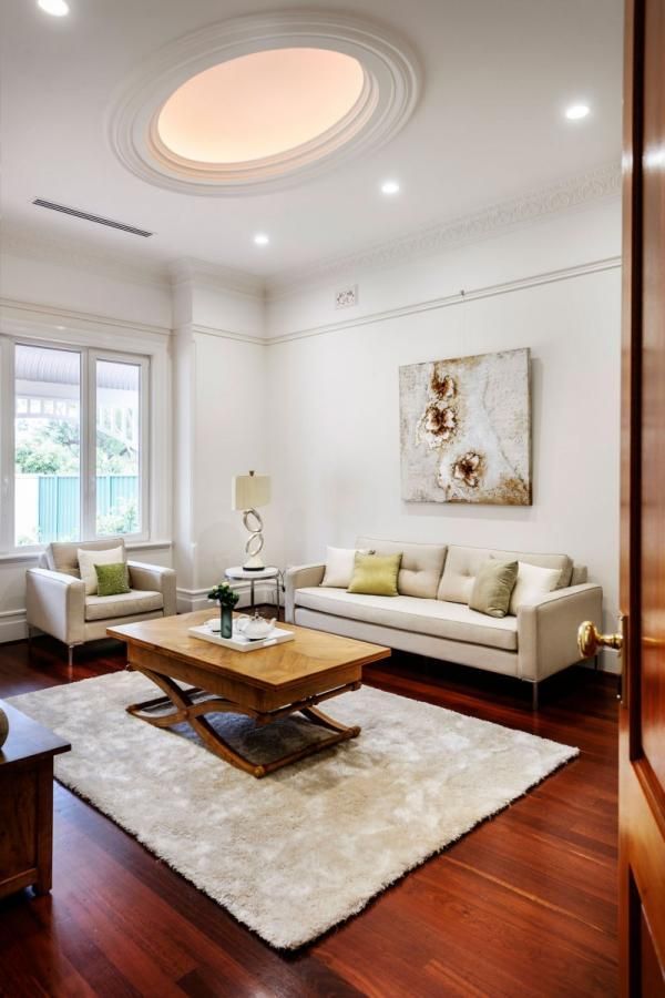 a living room filled with furniture and a large painting hanging on the wall above it