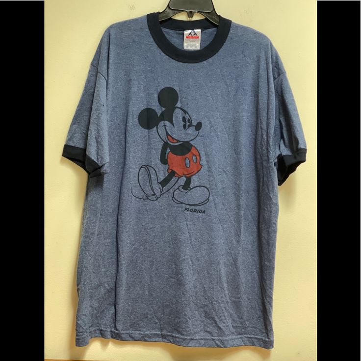 a mickey mouse t - shirt hanging on a wall