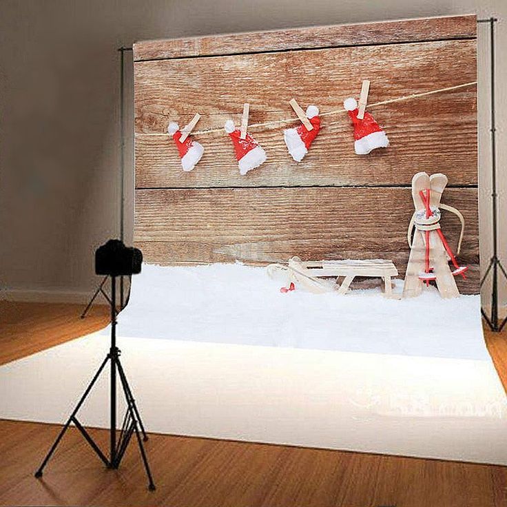 a photo shoot with a teddy bear and santa hats hanging on the clothes line in front of a wooden wall