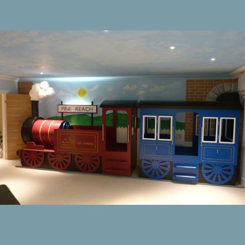 a toy train is in the middle of a playroom with other toys and furniture