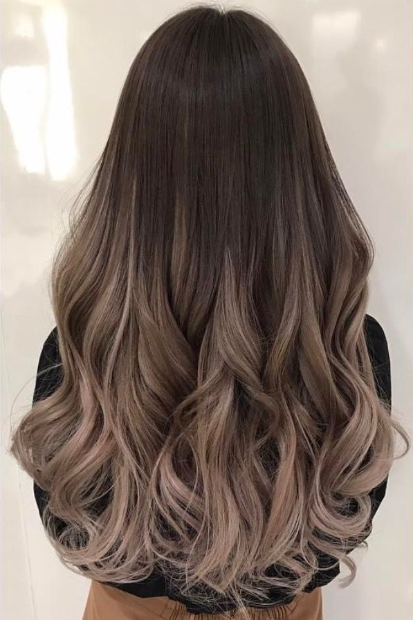 the back of a woman's head with long, wavy hair in grey tones