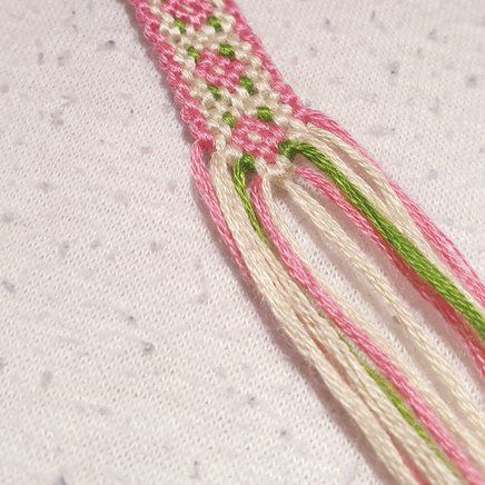 a pink and white piece of fabric with green trim