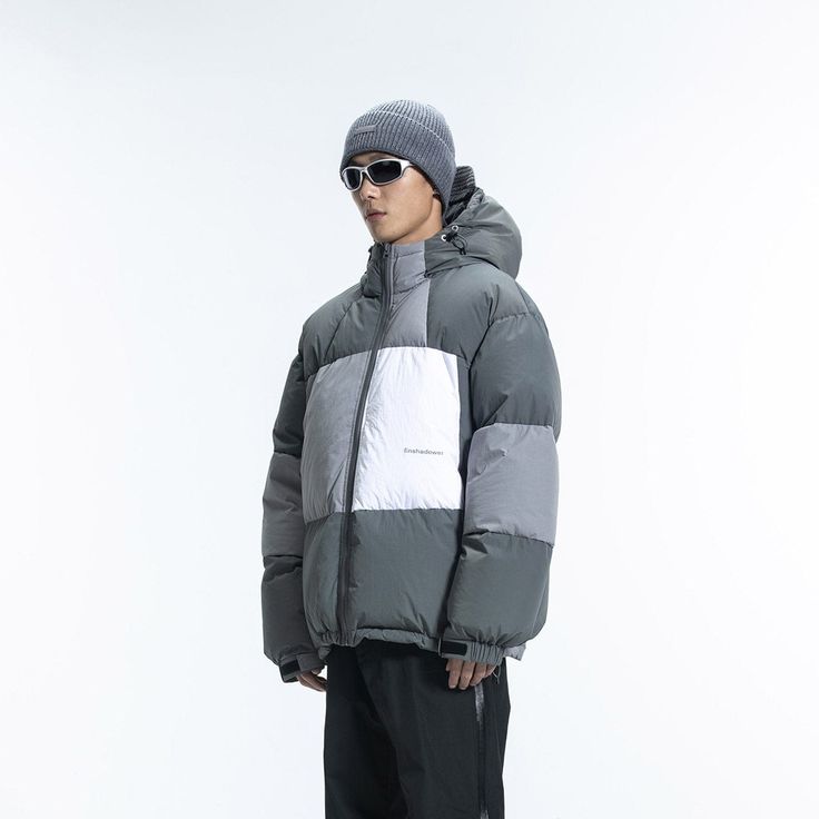 The Patchwork Down Jacket combines simplicity, avant-garde style, and vibrant energy. It features a Morandi color palette with a three-color splicing design, a logo print on the left waist, and an adjustable hood hem. The cuffs and jacket hem are snug, and the lining is made from anti-drilling velvet fabric. Filled with 268G of high-quality white duck down, this jacket is made from premium fabric and is slightly oversized.Morandi color scheme with three-color splicing design. Logo print on the l Gray Hooded Puffer Jacket For Outdoor Activities, Winter White Outerwear With Reflective Details, White Reflective Winter Outerwear, Green Sporty Puffer Jacket For Streetwear, Functional Long Sleeve Patchwork Outerwear, Gray Patchwork Outerwear For Streetwear, Winter Color Block Outerwear For Outdoor Activities, Techwear Patchwork Outerwear For Streetwear, Gray Urban Puffer Jacket For Streetwear