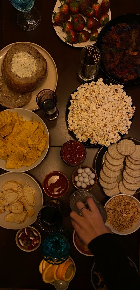 a table filled with lots of food on top of plates next to bowls and glasses