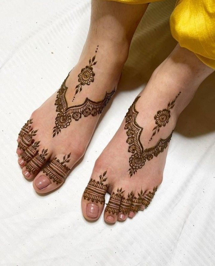 two feet with henna tattoos on them