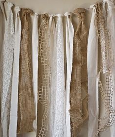 some white lace and burlap garlands hanging from a wall with the words wrap me in burlap