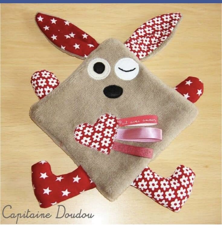 a stuffed animal with red and white stars on it's face, sitting on top of a wooden table